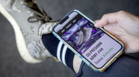 Endstate Cofounder Stephanie Howard uses her phone to check a pair of green Drop 0 sneakers and verify that they are authentic. (Robin Lubbock/WBUR)