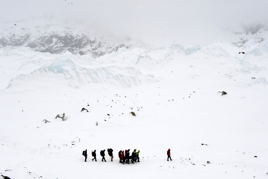 Rescuers carry a Sherpa injured by an avalanche that flattened parts of Everest Base Camp on April 25, 2015. A 7.8 magnitude earthquake hit Nepal and took at least 17 lives at Everest Base Camp, including seven Sherpas.