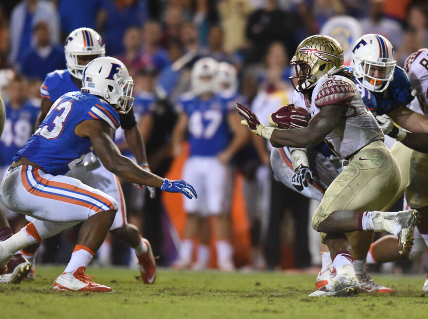 Florida State running back Dalvin Cook prepares to stiff-arm Florida linebacker Jeremi Powell during the teams' 2015 game. When they face off again Saturday, the Gators will be looking for their first win over the Seminoles since the 2012-13 season. (File/WUFT News)