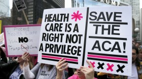 Protesters gather across the Chicago River from Trump Tower to rally against the repeal of the Affordable Care Act Friday, March 24, 2017, in Chicago. (Charles Rex Arbogast/AP)