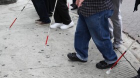 people using canes to walk down the sidewalk