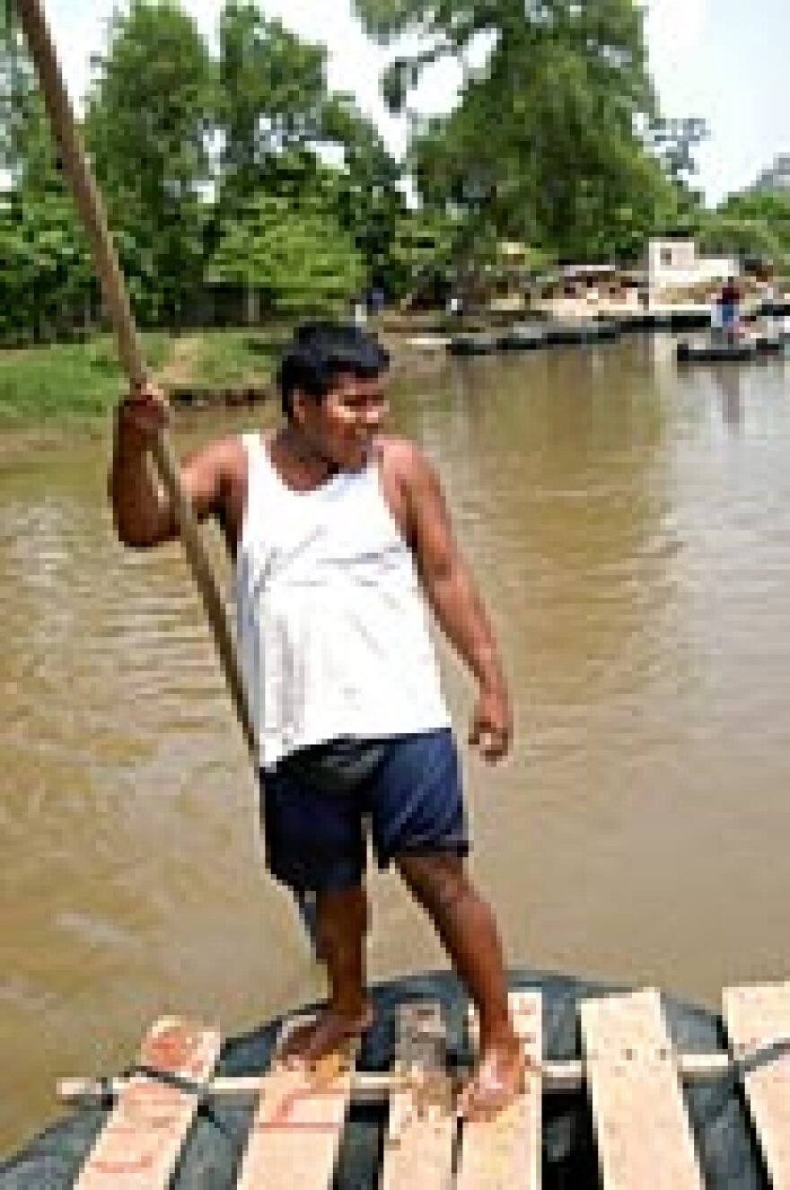 A poleman has a laugh as he bumps another raft on the muddy Suchiate River between Guatemala and Mexico. Each year several people are killed here in disputes over contraband.