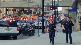 Officer Jennifer Chilton, (left), and an unidentified officer walk away from the Fifth Third Center minutes after the shooting.