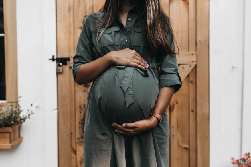 A pregnant woman holding her belly. 