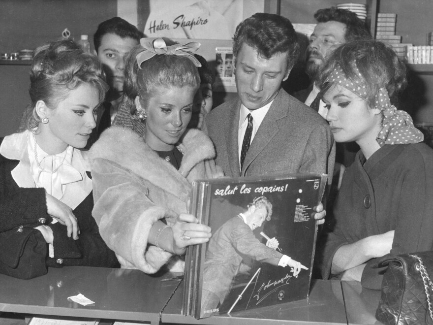 Johnny Hallyday and actress Catherine Deneuve find a copy of Hallyday's<em> Salut les Copains</em> album at a record shop in Paris in 1962.