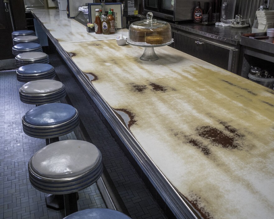 The well-worn counter of the Blue Benn Diner bears the evidence of supporting years of elbows, plates and coffee mugs.