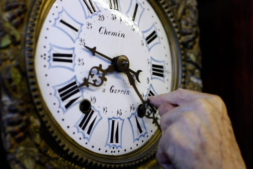 Howie Brown adjusts the time on a clock back one hour for the end of day light savings time at Brown's Old Time Clock Shop in Plantation, Florida.