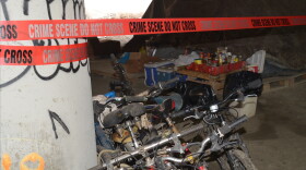 Police tape marks the scene of a shooting the left two people dead and three wounded in a homeless camp known as 'The Jungle,' under Interstate 5 in Seattle.