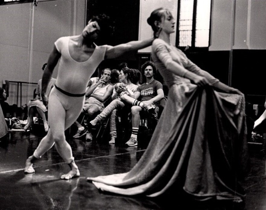 Black and white photo of male dancer leaning into a female dancer who leans back into his hand.