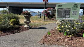 A sign, markers and a chalk outline help demonstrate the projected location of marshes by the end of the century, because of rising sea levels, at the Port Norfolk Beach Reflection Walk in Portsmouth on April 21, 2026.