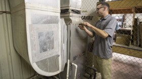 Service technician Tyler Pabst demonstrates the servicing of a geothermal unit in Norman Wednesday. 