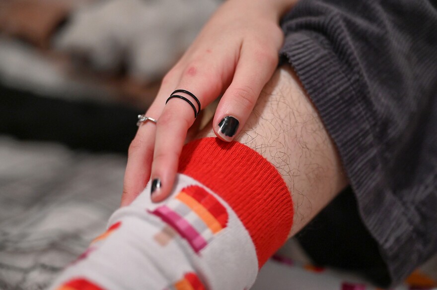 Kennedy Robbins adjusts their lesbian pride flag sock on Thursday, March 14, 2024, at their home in Columbia. “I love women. I love women so much. Like, it's absurd how much I love women, and I want that to be known,” Robbins said. “Like, the history of everything that's associated with the word lesbian. I know some people don't like that word. It’s used for a lot of things like, you know, porn categories, and this, this and that and all the different stigmatism that's associated with it. And, growing up, I thought lesbian was a dirty word because of how people treated the word. It seems like it's a dirty word. But, that's one of the reasons why I like it so much: because I get to reclaim it. It's not this awful, dirty thing. It's really beautiful. And I want to honor those who have fought hard, have used these labels and fought hard to get us where we’re at today.”