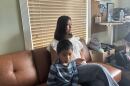 Wendy Domingo, 18, sits on a couch at the Guatemalan-Maya Center in Lake Worth Beach alongside her little brother. She is now the adult in charge of her four siblings after Border Patrol agents pulled over and detained both her parents in front of them all.