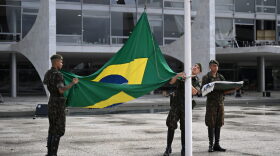 Soldiers hoist a new Brazilian flag at Planalto Palace in Brasilia.