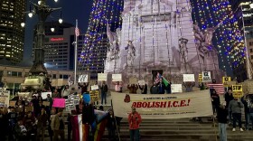 protestors holding signs saying abolish ice