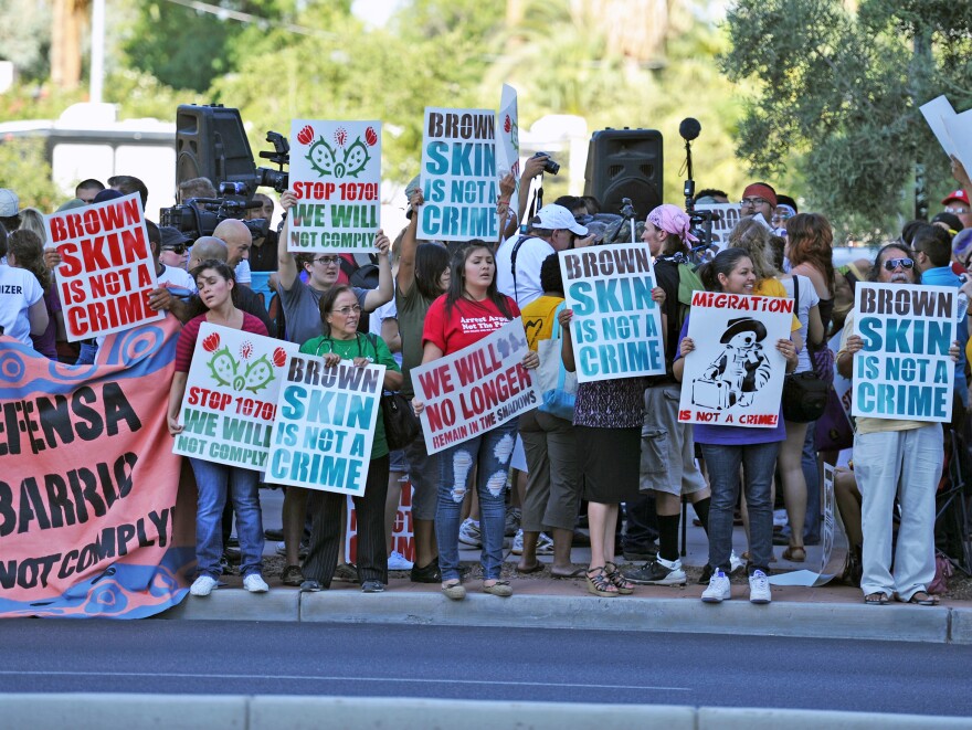 Demonstrators line the curb in reaction to the U.S. Supreme Court's decision on Arizona's immigration law, near the Immigration and Customs Enforcement offices in Phoenix on Monday.