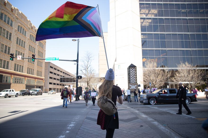 Wichita State University Student Government Senator Evelyn Lewis raises a pride flag while marching in the No Kings protest in Wichita, Kan. on Saturday, March 28, 2026.