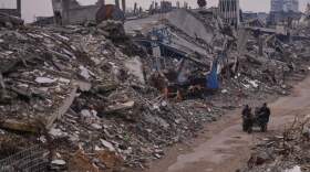 Palestinians pass along a street surrounded by buildings destroyed during Israeli air and ground operations in the Sheikh Radwan neighborhood, in Gaza City, Tuesday, Dec. 30, 2025. (Abdel Kareem Hana/AP)