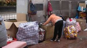 This photo taken on Feb. 20 shows a foreign worker in Hong Kong sheltering with her belongings during the city's current coronavirus surge.