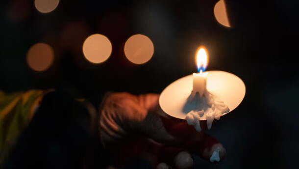 Candle wax melts onto an attendee’s finger during a vigil at Drake Park after three children and a teacher were killed in a mass shooting at Silver Rail Elementary School in Bend, Ore. on Oct. 15, 2026. The suspected shooter was a 16-year-old who entered the school and was killed by an armed bystander, bringing the total number of deaths to five.