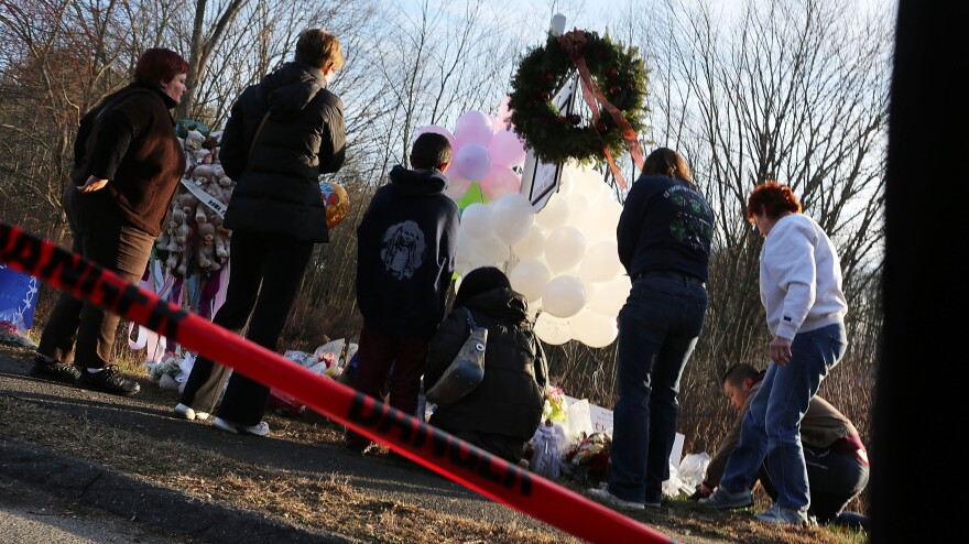 People visit a memorial outside Sandy Hook Elementary School in Newtown, Conn., on Dec. 15.