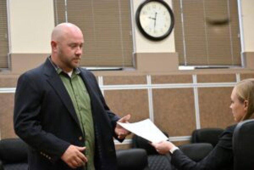Lincoln County District Attorney Jenna Wallace hands Aaron Paulsen a document detailing misdemeanor child neglect charges against him during his arraignment last November. His trial is now scheduled this November.