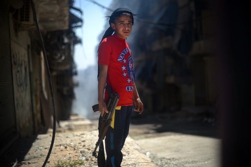 A Syrian boy holds an AK-47 assault rifle in the majority-Kurdish Sheikh Maqsud district of the northern Syrian city of Aleppo in April.