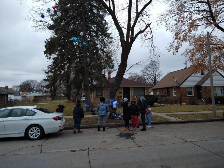 Some of the people mourning the death of postal carrier Aundre Cross gather at the vigil site.