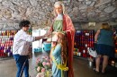 Members of the faithful come to touch the St. Ann sculpture, light candles and leave their intentions during St. Ann's Novena.
