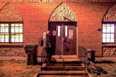 A man stands outside a shelter entrance at a church in Concord, NH.