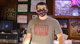 Bartender Billy Search is behind the bar at The Little Bar while wearing a mask.