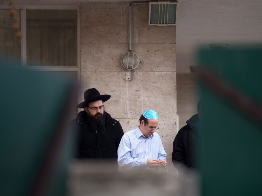 Members of Marseille's Jewish community gather in front of a Jewish school after the attack took place on Monday.