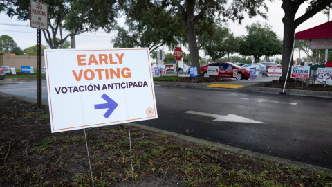 A sign directs early voters to election officials at the Orange County Public Library Alafaya Branch on the morning of Monday, Oct. 19, the first day of early voting in Orange County.