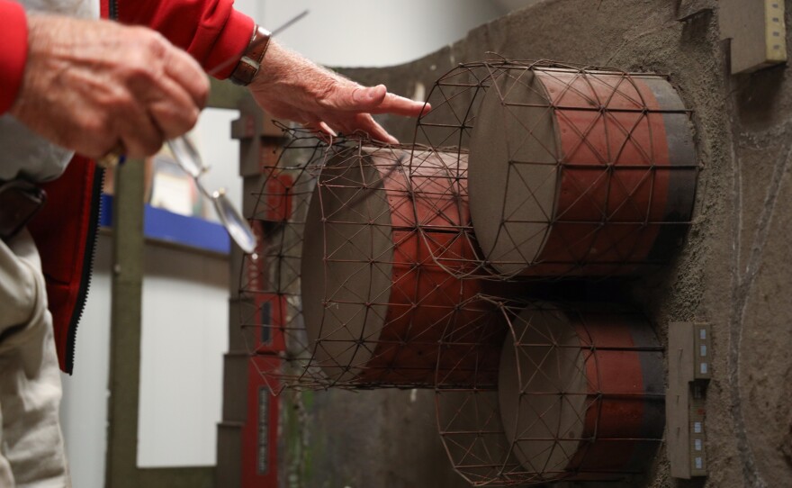 Clark L. Rittersbach adjusts the framework on the replica gas storage tanks in his diorama of the Genesee River gorge, which depicts the operations of Rochester Gas & Electric, Bausch + Lomb, and other small businesses such as Upton Cold Storage from the early 1900s.  Rittersbach, who used to work for RG&E, salvaged the large-scale model in the early 1970s from RG&E's former offices in the Genesee River gorge.