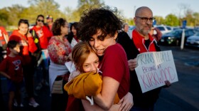 Hollis Moore, a 30-year-old teacher in the Kirkwood School District, hugs their student Maggie McCoy, 10, on Monday, April 17, 2023, before a school board meeting outside North Kirkwood Middle School in Kirkwood. Moore alleges they have been discriminated against by district officials due to their gender identity.
