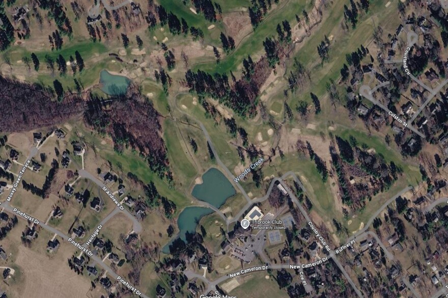 A satellite image of the golf course from Google Maps shows the irrigation pond towards the bottom of the picture, with Woods Creek running roughly northeast through the course.
