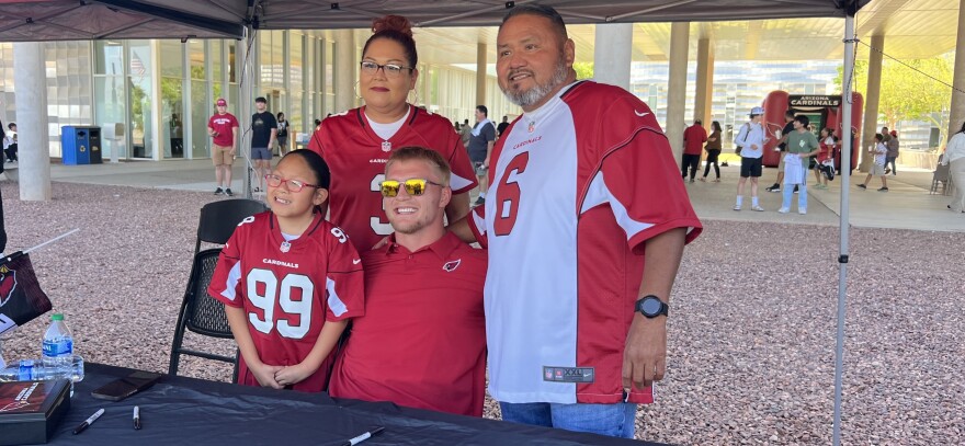 Cardinals fans Ayizanna, Christine and Garrison Yazzie of Yuma pose for photos with tight end Trey McBride during the Cardinals Caravan stop at Arizona Western College on Tuesday, May 9, 2023.