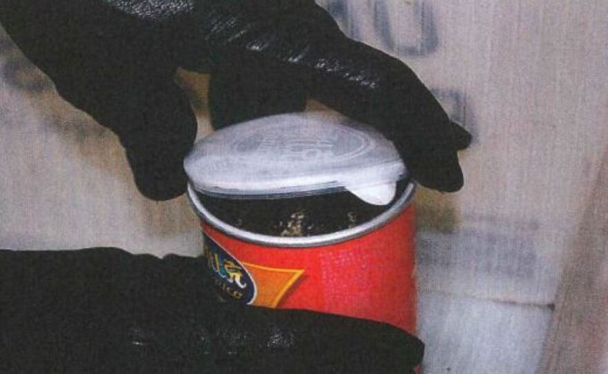 A special agent of the U.S. Fish and Wildlife Service opens the first of three chip cans that held snakes instead of snacks.