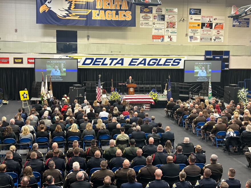 Pastor Brian White of Harvest Church starting the funeral service at Delta High School.