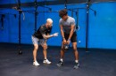 Coach Donnie Keller instructs a student of Wilson's Fit Futures in proper lifting technique.