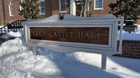 Image outside of Delaware's Legislative Hall in Dover during the winter. Sign surrounded by snow reads "legislative hall."