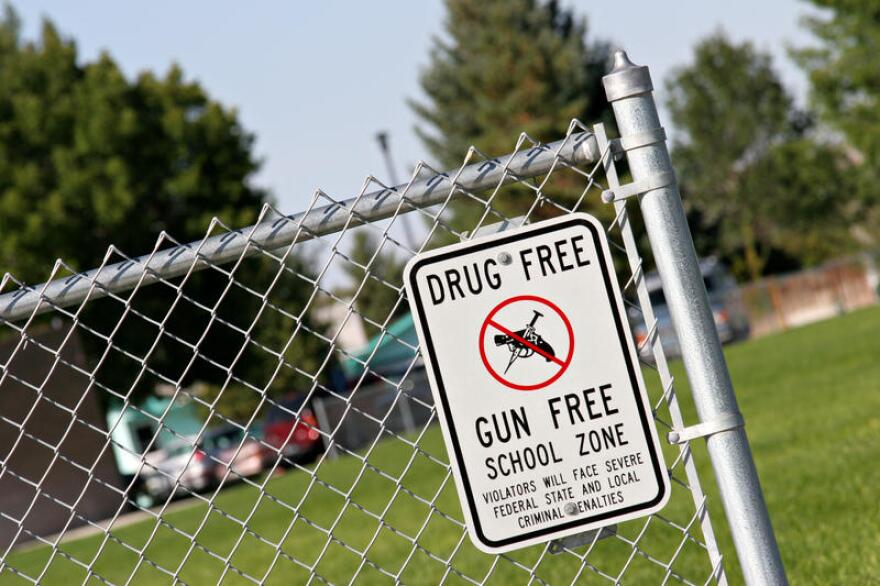 gun free zone sign on chain link fence