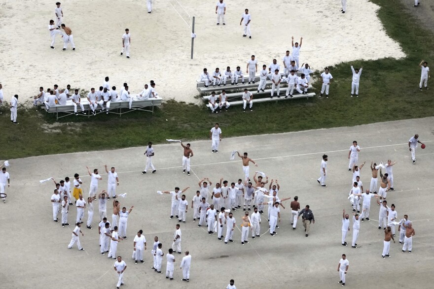 Detainees wave and spell out a rough SOS to a helicopter flying overhead, at U.S. Immigration and Customs Enforcement's Krome Detention Center, Friday, July 4, 2025, in Miami. (AP Photo/Rebecca Blackwell)
