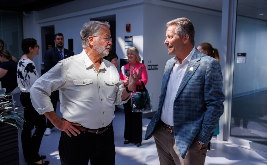 U.S. Sen. Gary Peters, left, and Michigan State University President Kevin Guskiewicz, right, visit the Facility for Rare Isotope Beams in East Lansing, Mich., on Aug. 28, 2026. The visit was the last stop on Peters' final motorcycle tour of Michigan as senator.