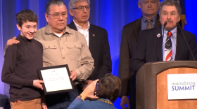 Thomas George and his grandson accept an award on behalf of Tlingit, Haida, and Tsimshian people for the traditional halibut hook. (Photo courtesy of 360 North/Juneau Economic Development Council)
