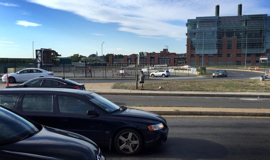 Host Robin Young stands at Boston's Cambridge Street bus stop by the on- and off-ramps for Interstate 90. It was voted the second-worst bus stop in the country, according to Streetsblog USA. (Robin Young/Here & Now)