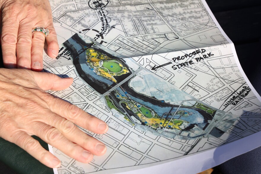 Genesee Land Trust Executive Director Gay Mills shows a map outlining a proposed state park at the base of High Falls. Under Mills' leadership, GLT envisioned a new life for the 40 acres of rocky riverfront and partially wooded terrain.