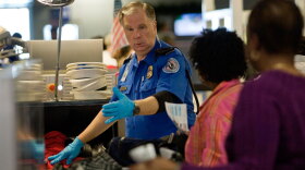 A TSA officer screens airline passengers at the Dallas/Fort Worth International Airport on Sunday. Preflight screenings were stepped up after a man was accused of trying to blow up a Northwest Airlines flight Friday.