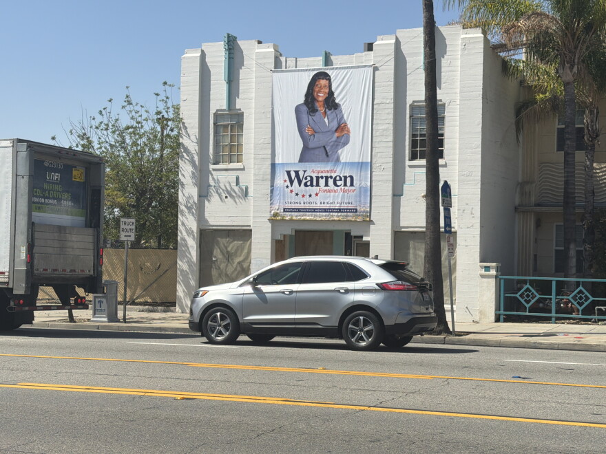 An election campaign banner of Mayor Acquanetta Warren hanging from a building on Sierra Avenue near City Hall in Fontana.