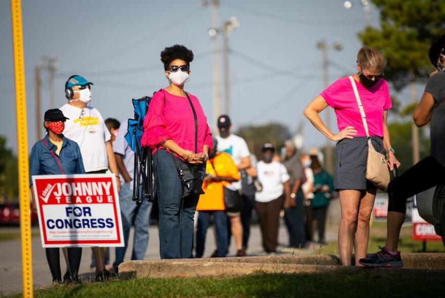 Harris County residents wait in line at Houston's Bayland Community Center during the first day of early voting.